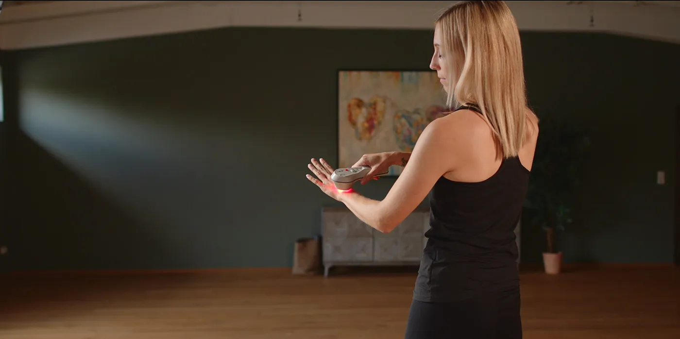 Frau verwendet das Spectra-H lux Lasertherapiegerät am Handgelenk